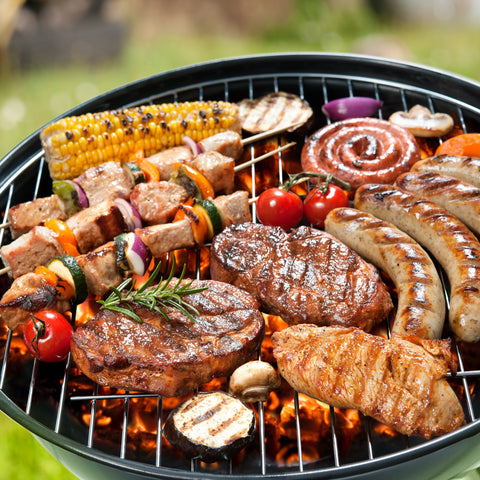 seasoned meats and vegetables on a BBQ flame grill