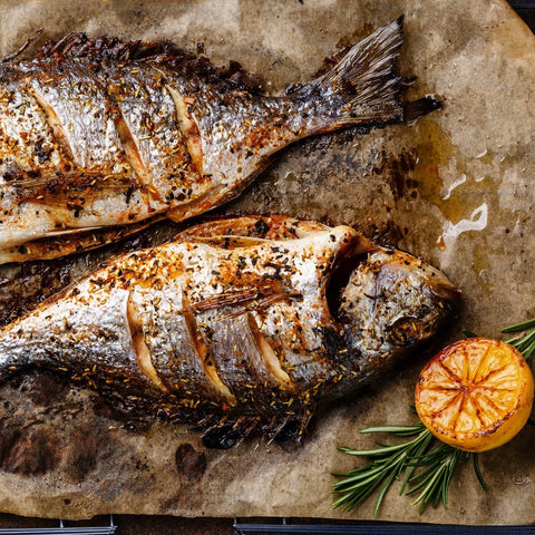 Grilled and seasoned fish on grease proof paper